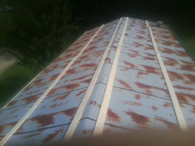 Rusted metal roof panels with new wood purlins before replacement — Storm Damage Roof Repair in Willowbrook by Roofing Brothers